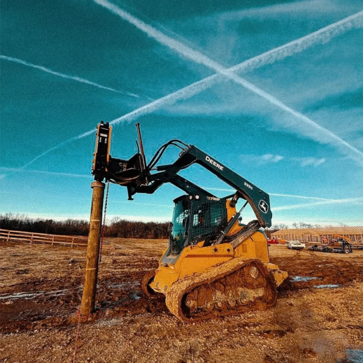 Contractor installing wooden posts for a horse corral in the Chicago area