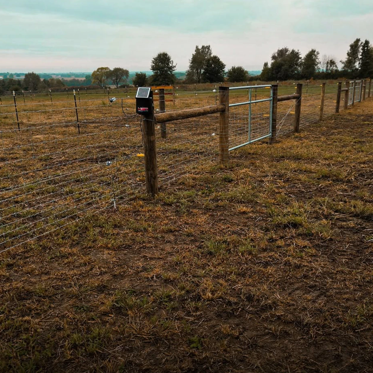 Woven-wire farm fencing with an equipment access gate