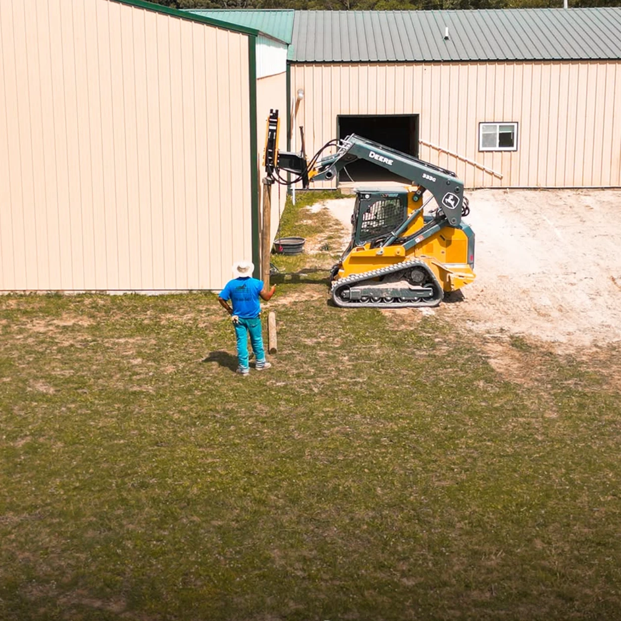 Commercial farm fence installation near an agricultural building