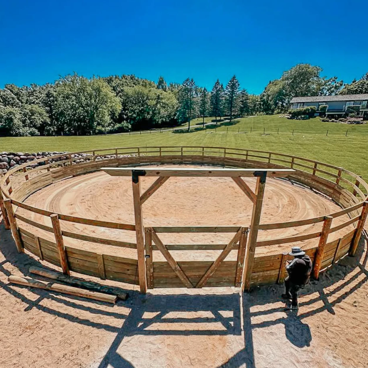 Visible rail derby fencing around a circular horse training area