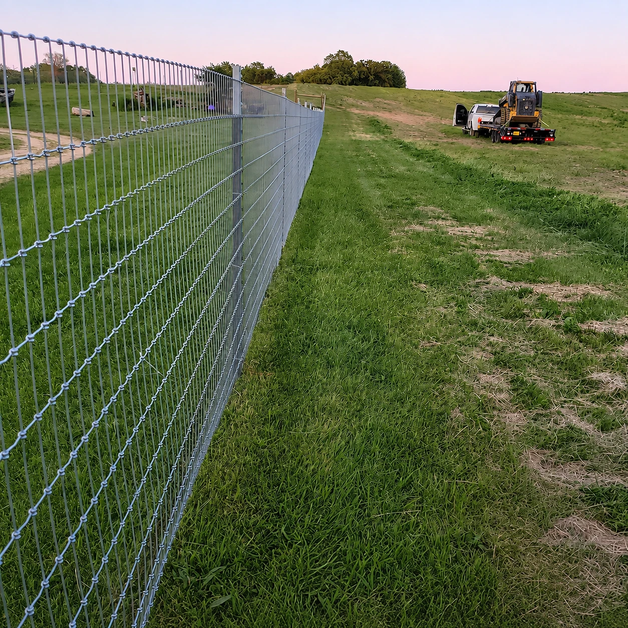 Newly installed woven-wire fence along an agricultural field