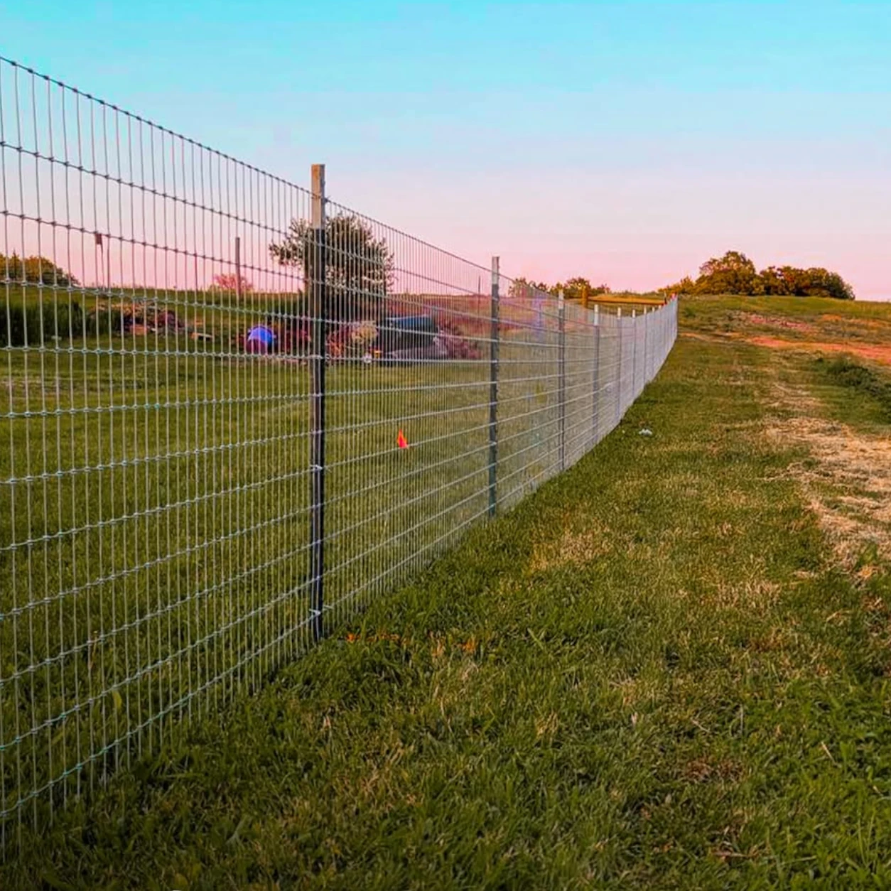 Woven-wire perimeter fencing installed along a rural property